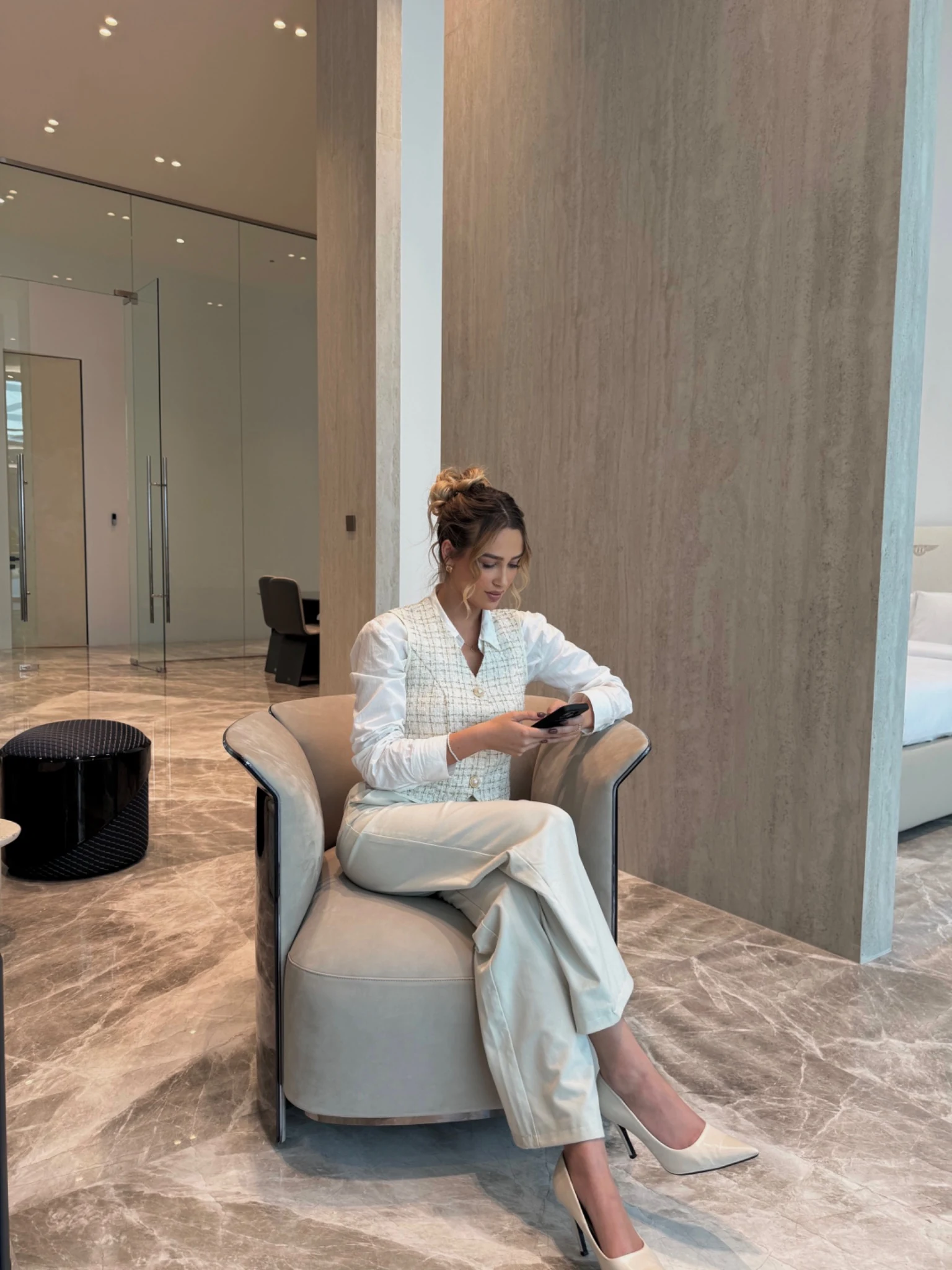 Lilly sitzt in einem hellen Lounge-Sessel